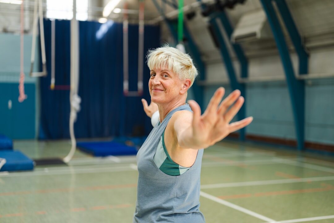 Seniors doing a gentle fitness stretching class in a bright hall